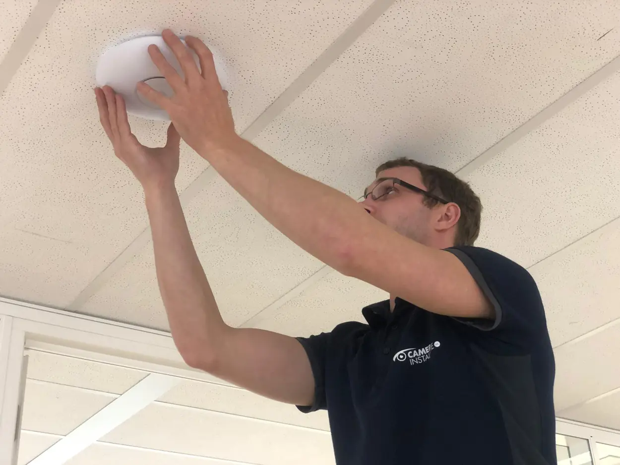 Onze monteur plaatst een wifi-punt in een systeemplafond